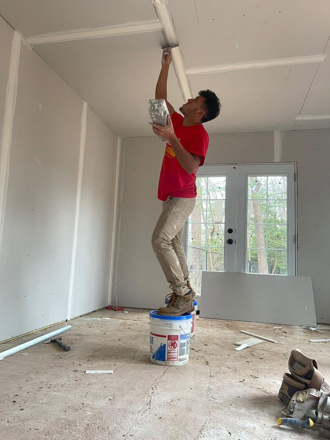 E.T. General Contractor crew member finishing a drywall ceiling on a home project