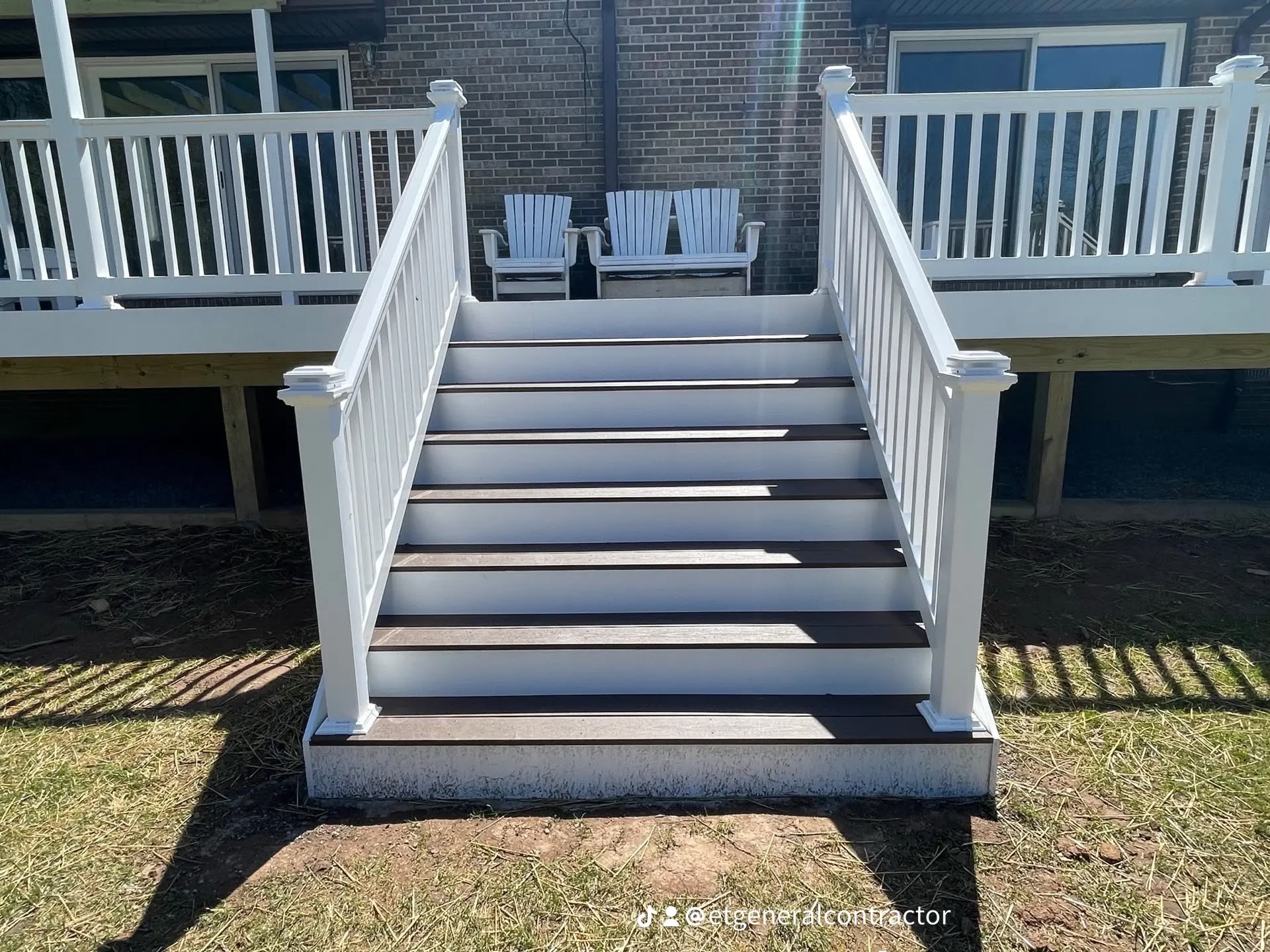 Composite deck stairs with white vinyl railing built by E.T. General Contractor